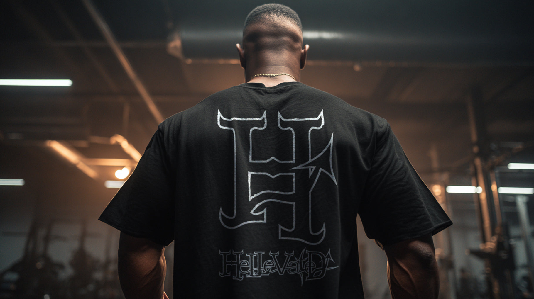 Muscular man wearing a H for Hellevated Oversized T-shirt, back pointed at camera.